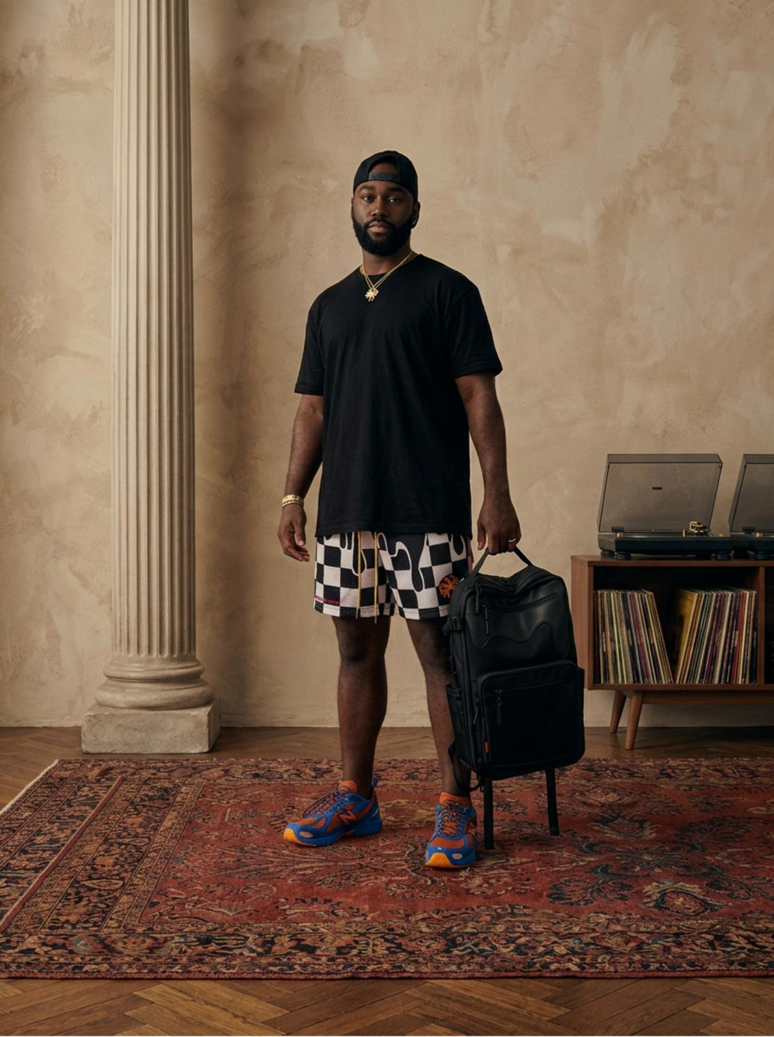 Michael Harris holding a black bag in a room with rockstar shorts on