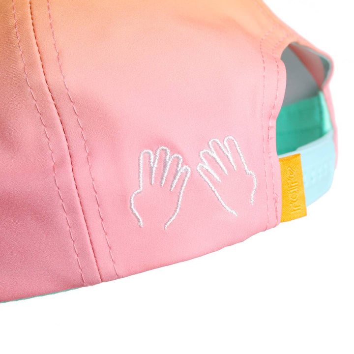 Translation missing: en.Close-up side panel of the cap featuring two small white embroidered hand symbols near the teal snapback with a yellow rare tab