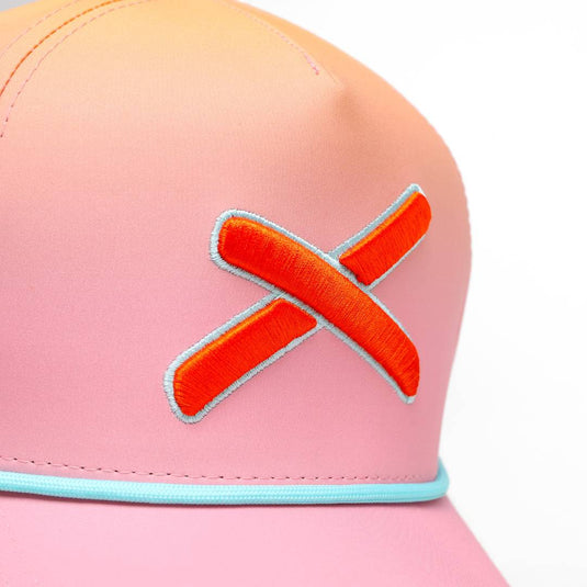Close-up of the cap’s front panel highlighting the textured orange X embroidery.