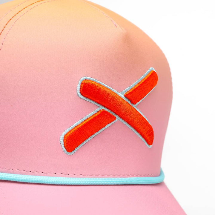 Translation missing: en.Close-up of the cap’s front panel highlighting the textured orange X embroidery