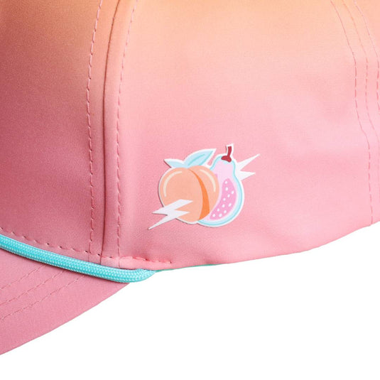 Side view of the cap showcasing a peach and splash graphic embroidered on the pink gradient panel near the brim.