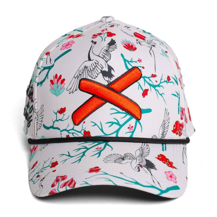 Translation missing: ja.front view of a floral patterned baseball cap featuring bird illustrations, orange X logo