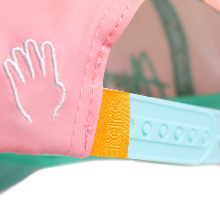 Translation missing: en.Close-up of the embroidered hand icons and the yellow-and-teal adjustable snap closure on the back of the cap